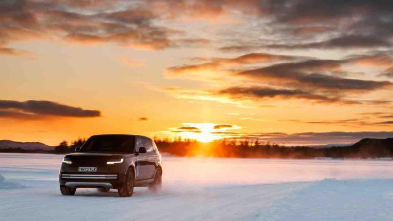 Range Rover Electric - Front- und Seitenansicht im Schnee mit Sonnenuntergang - bei Automagazin Plus